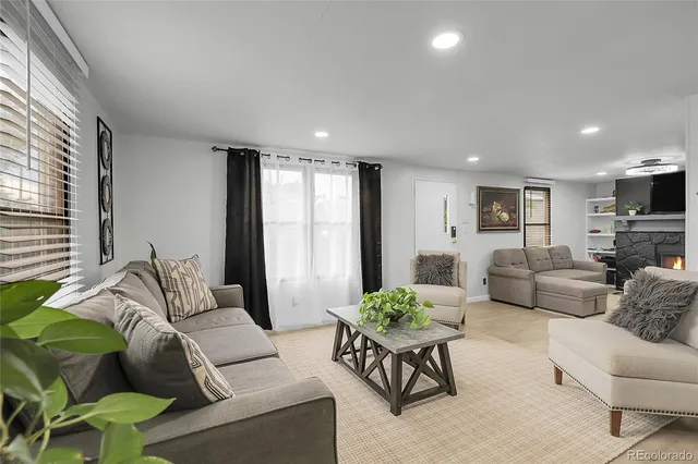 a living room with furniture fireplace and a large window