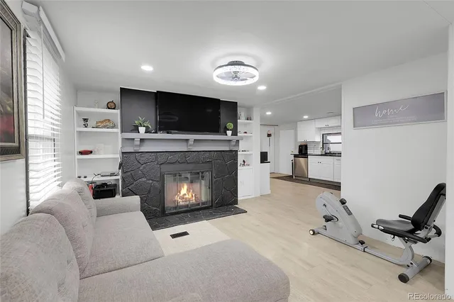 a living room with furniture a flat screen tv and a fireplace