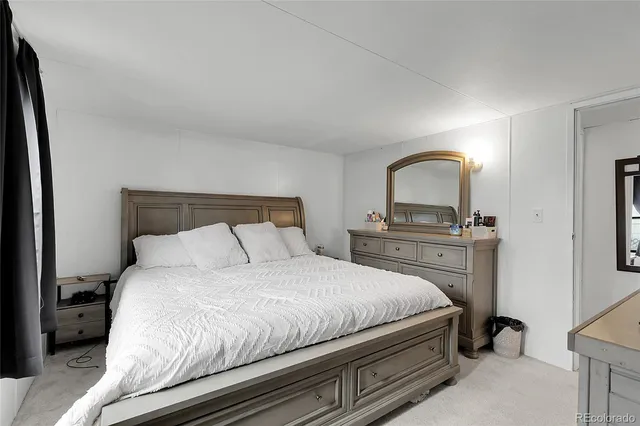 a bedroom with a bed and a mirror on dresser