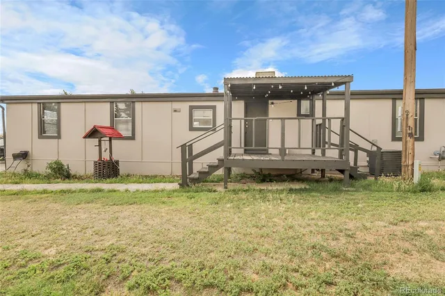 a backyard of a house with a yard table and chairs