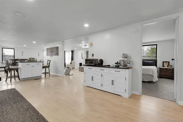 a open white kitchen with cabinets table and chairs