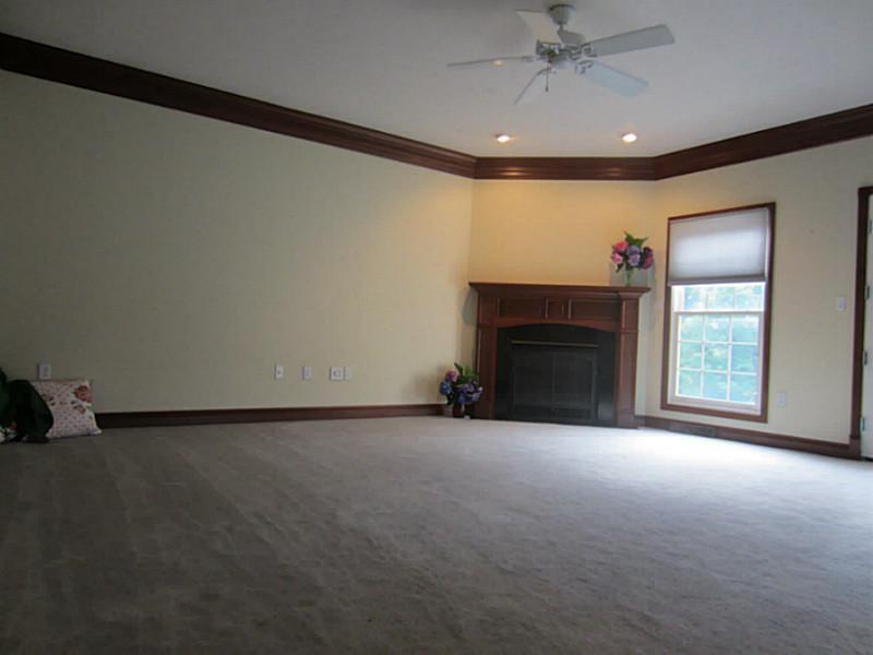 77 Shenot Road Wexford, PA 15090 - Photo 15 of 25 Living Room. Crown molding. Wood-encased gas fireplace. Ceiling fan and lined with windows & patio doors to deck.