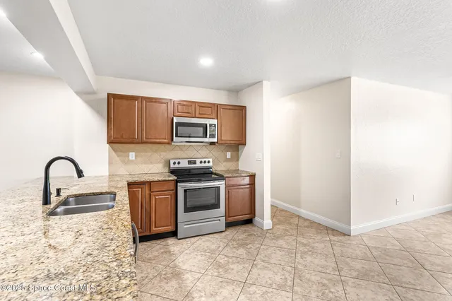 a kitchen with granite countertop a refrigerator and a sink