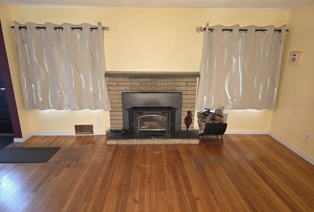 118 Spruce Road Norwood, MA 02062 - Photo 2 of 39 a view of a livingroom with wooden floor and a fireplace
