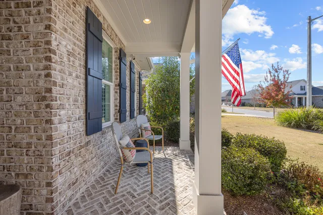 a kitchen with stainless steel appliances kitchen island granite countertop a refrigerator oven a sink dishwasher and white cabinets with wooden floor