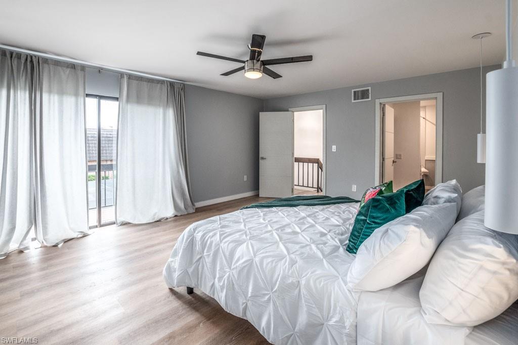 124 Lake Point Lane, Unit 2B Naples, FL 34112 - Photo 17 of 41 a bedroom with a large bed and a chandelier