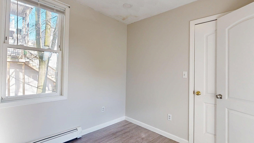 329 Paris Street, Unit 2 Boston, MA 02128 - Photo 13 of 24 a view of an empty room with wooden floor and windows