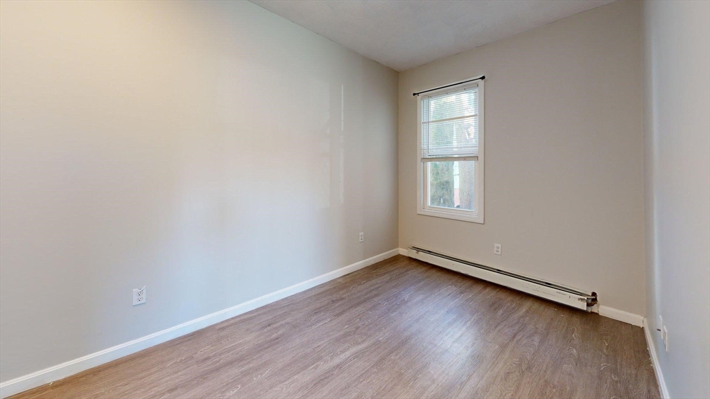 329 Paris Street, Unit 2 Boston, MA 02128 - Photo 17 of 24 an empty room with wooden floor and windows