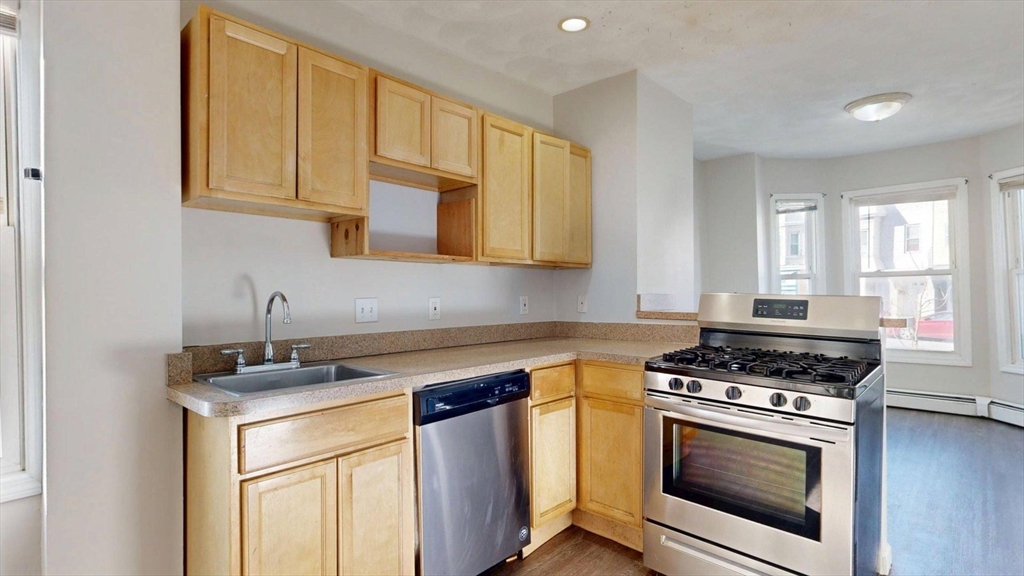 329 Paris Street, Unit 2 Boston, MA 02128 - Photo 2 of 24 a kitchen with stainless steel appliances granite countertop a stove a sink and a microwave