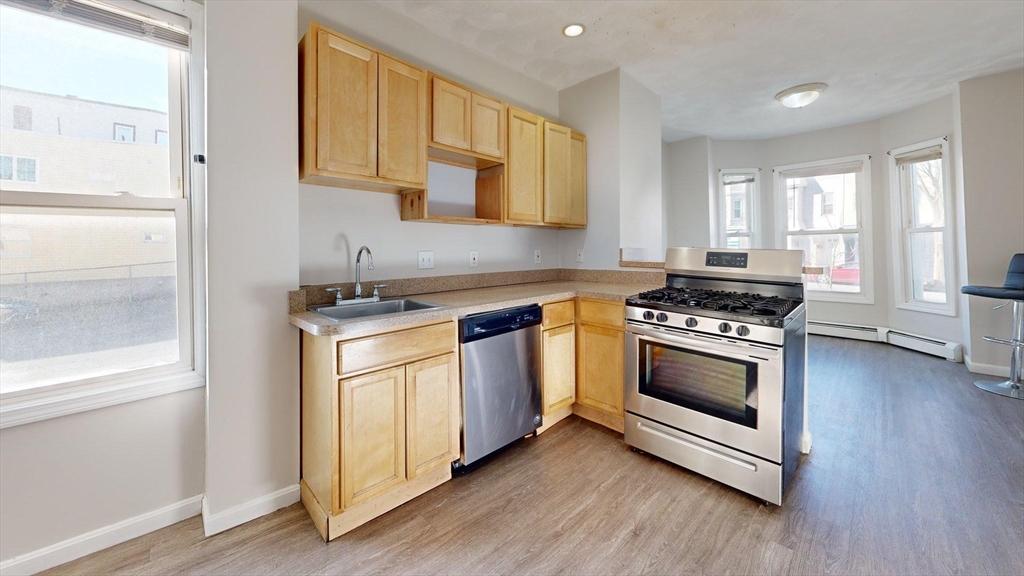 329 Paris Street, Unit 2 Boston, MA 02128 - Photo 23 of 24 a kitchen with granite countertop cabinets and steel stainless steel appliances