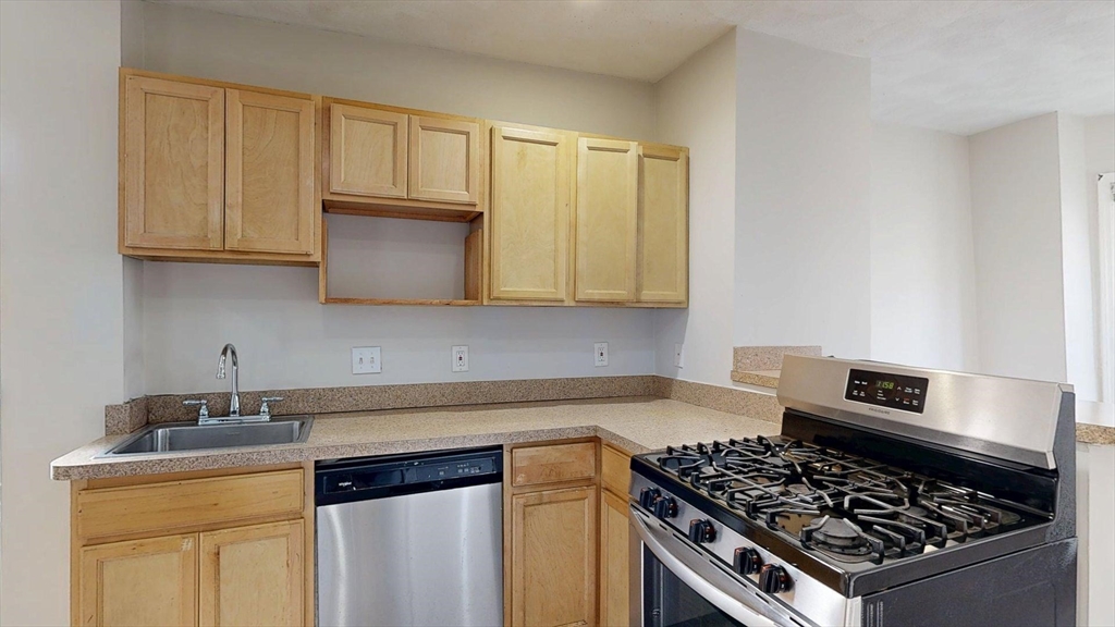 329 Paris Street, Unit 2 Boston, MA 02128 - Photo 6 of 24 a kitchen with granite countertop a stove and a sink