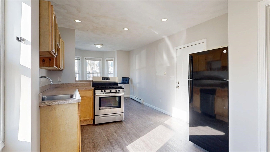 329 Paris Street, Unit 2 Boston, MA 02128 - Photo 7 of 24 a kitchen with a stove and a refrigerator