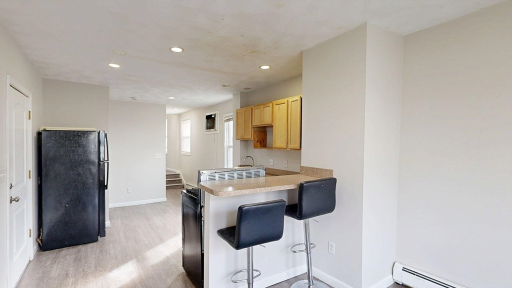329 Paris Street, Unit 2 Boston, MA 02128 - Photo 10 of 24 a kitchen with a sink cabinets and a refrigerator