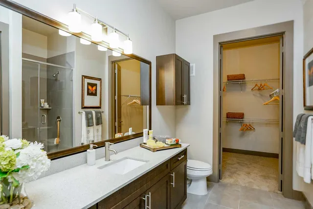a bathroom with a double vanity sink toilet and shower