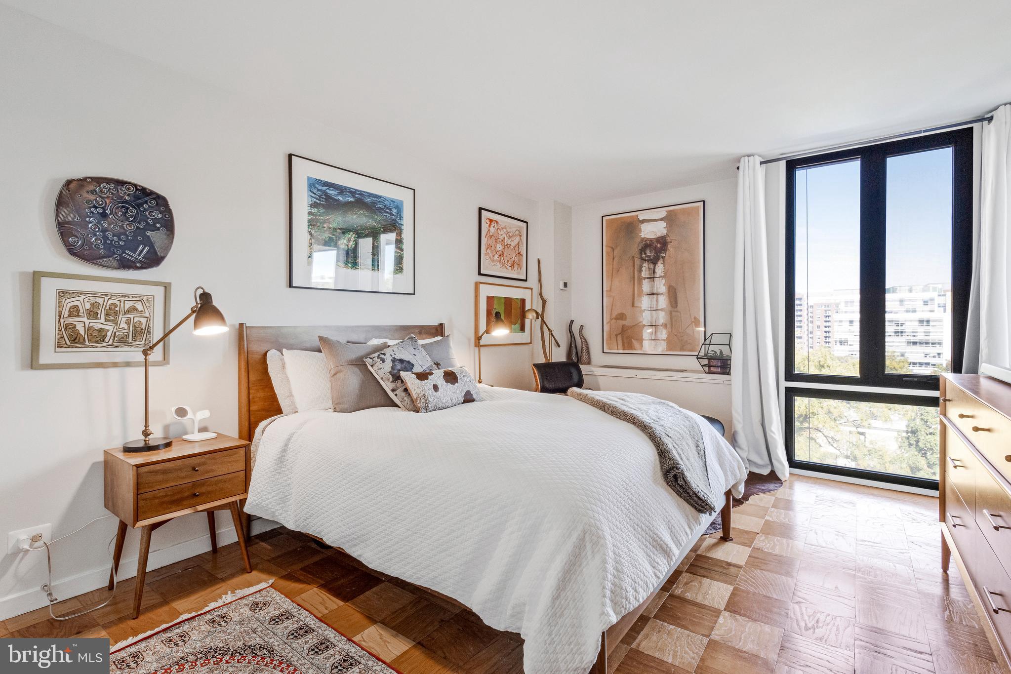 1245 4th Street Southwest, Unit E501 Washington, DC 20024 - Photo 19 of 40 a bedroom with a bed a painting and a window