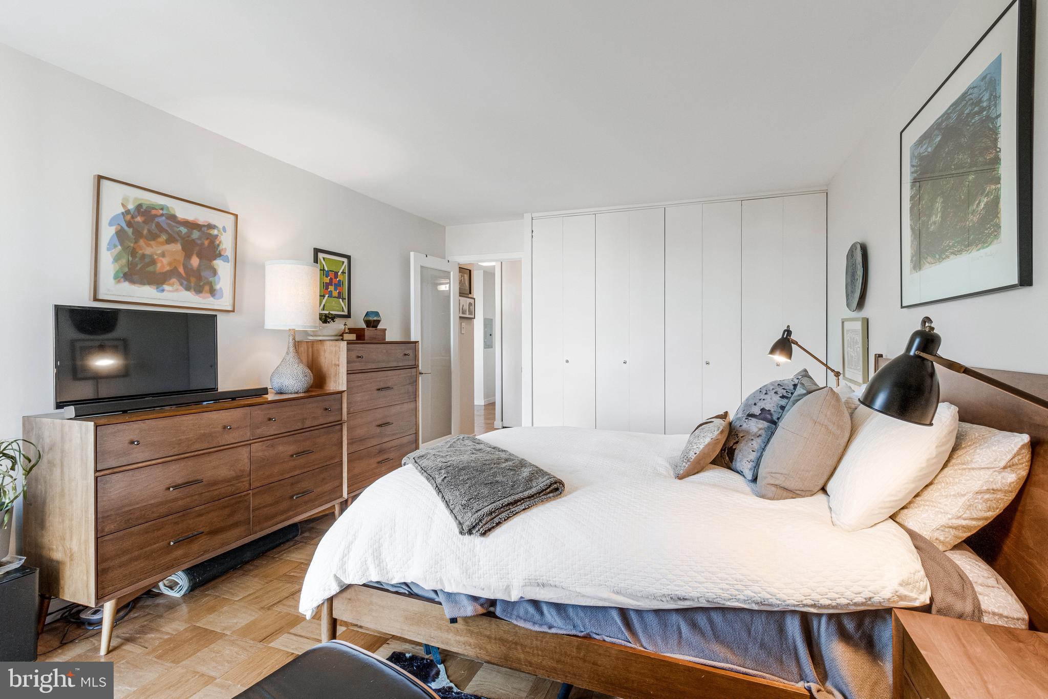 1245 4th Street Southwest, Unit E501 Washington, DC 20024 - Photo 21 of 40 a bedroom with a bed and wooden floor