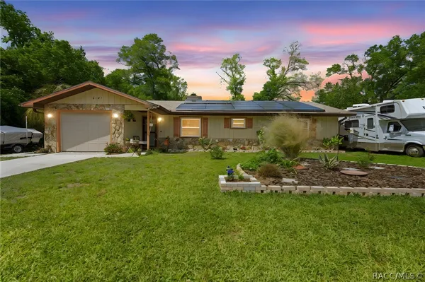 a front view of a house with a yard and outdoor seating