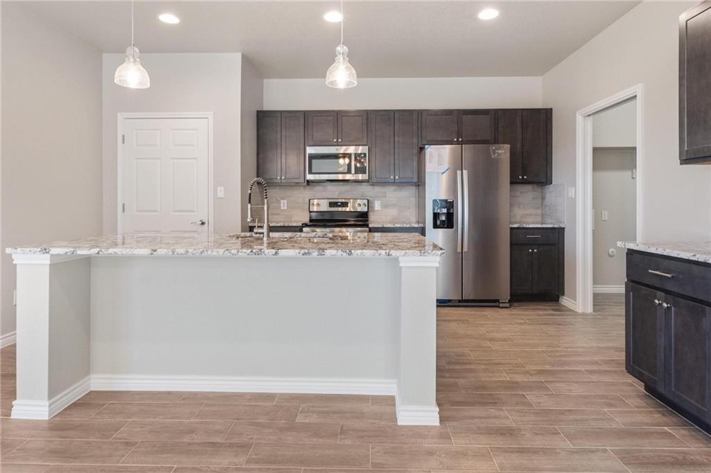 365 County Road 306, Unit A Jarrell, TX 76537 - Photo 2 of 9 a kitchen with stainless steel appliances granite countertop a refrigerator a sink a stove and oven