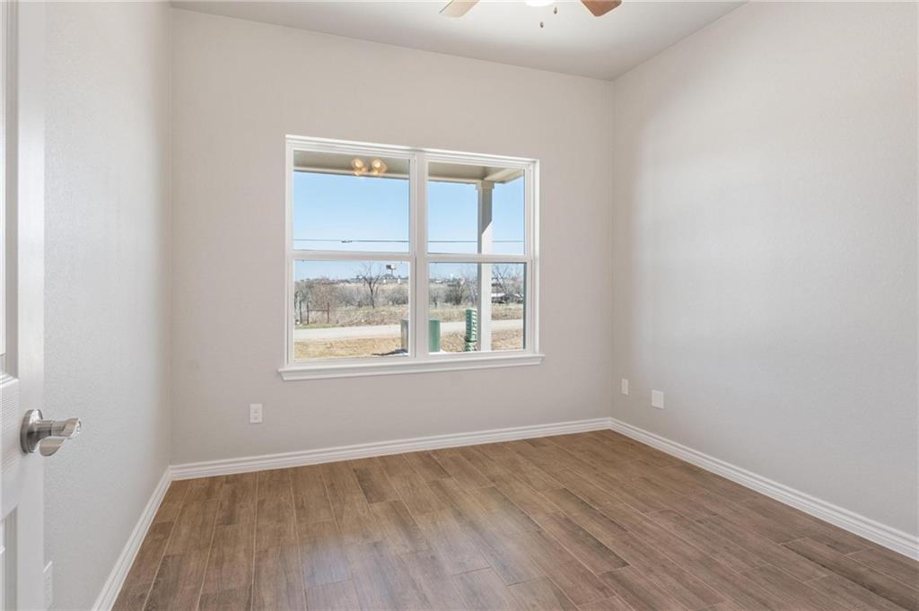 365 County Road 306, Unit A Jarrell, TX 76537 - Photo 5 of 9 an empty room with wooden floor and windows