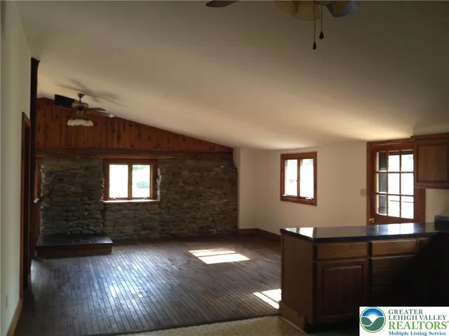a view of a living room with kitchen island granite countertop furniture and a fireplace