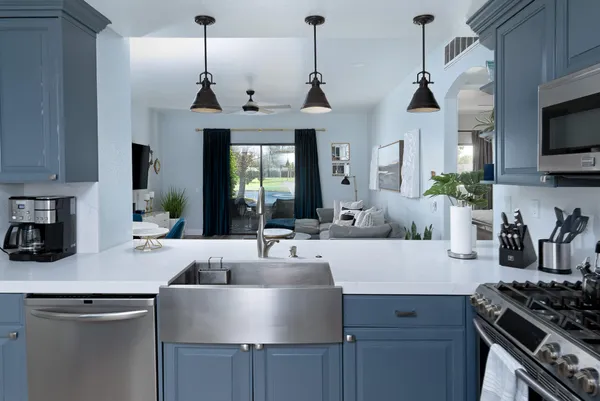 a kitchen with stainless steel appliances a sink a stove and a wooden floor
