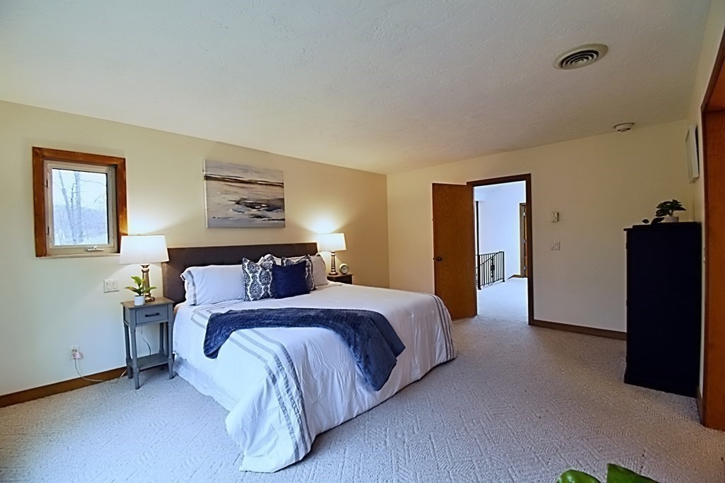 8 McCarthy Circle Framingham, MA 01702 - Photo 16 of 42 a bedroom with a bed and a walk in closet