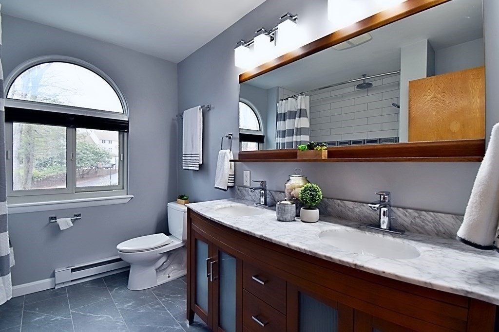 8 McCarthy Circle Framingham, MA 01702 - Photo 25 of 42 a bathroom with a granite countertop sink a large mirror and a window