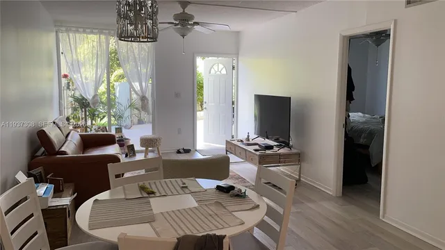 a living room with furniture a chandelier and a flat screen tv