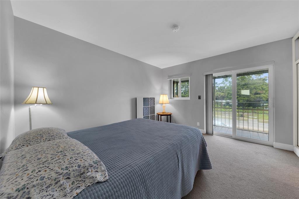 11 Southwest 4th Avenue, Unit 10 Boca Raton, FL 33432 - Photo 17 of 32 a spacious bedroom with a bed and a lamp