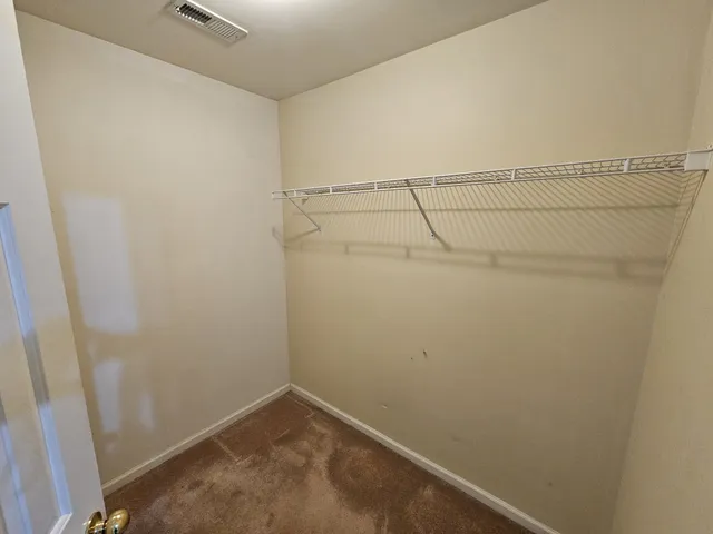 an empty room with a window and a ceiling fan