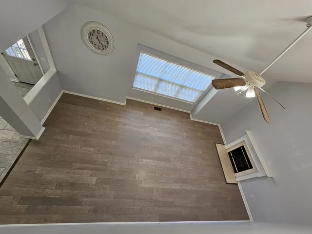 an empty room with a ceiling fan and a window