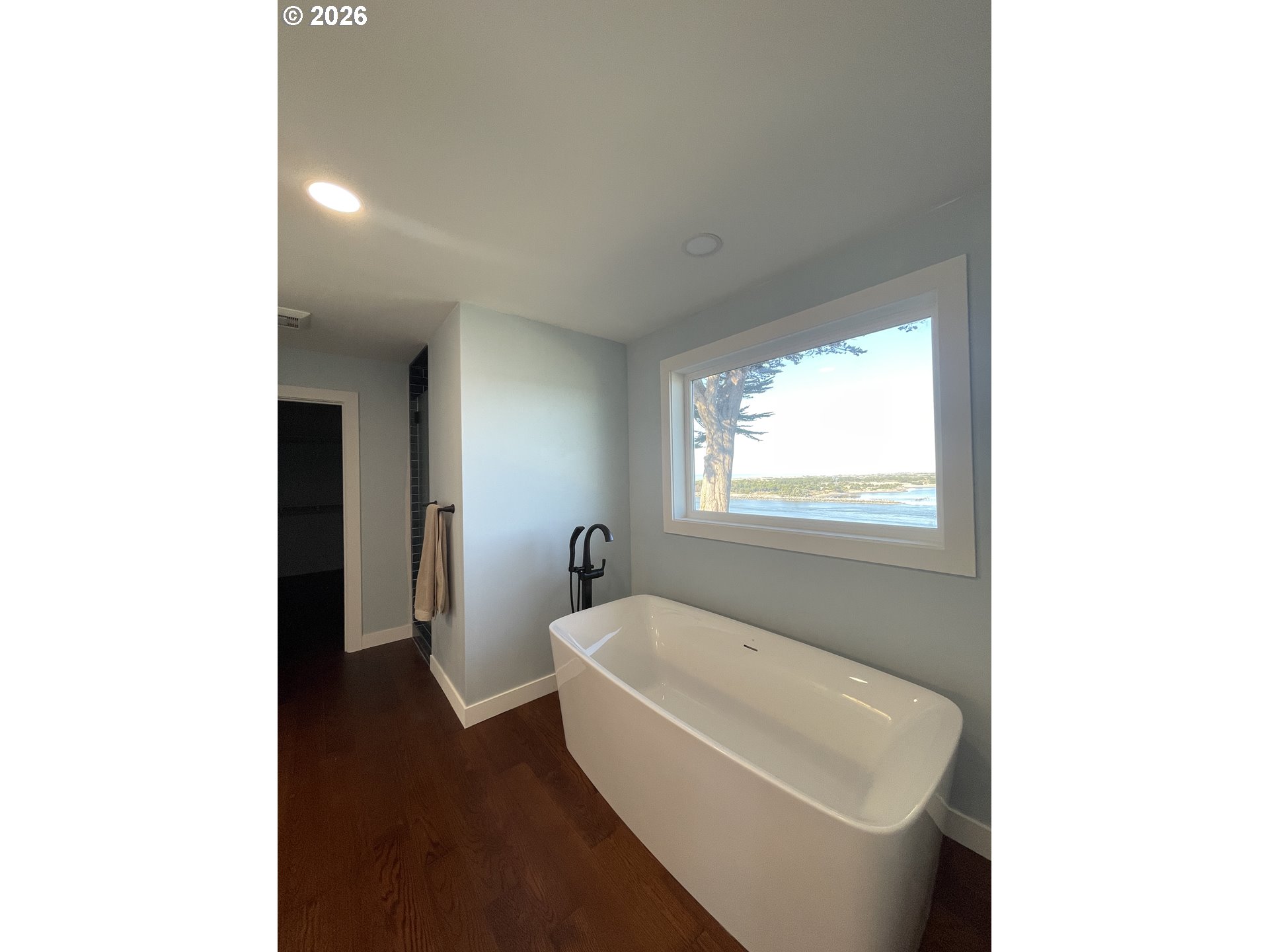 360 2nd Street Southeast Bandon, OR 97411 - Photo 18 of 28 a bathroom with a bathtub and window