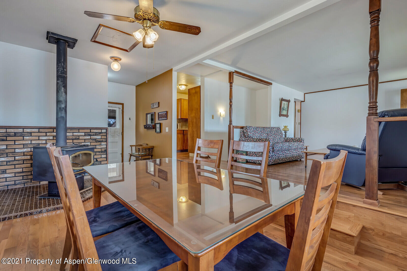 446 Elm Avenue Rifle, CO 81650 - Photo 9 of 28 a dining room with wooden floor a chandelier a wooden table and chairs