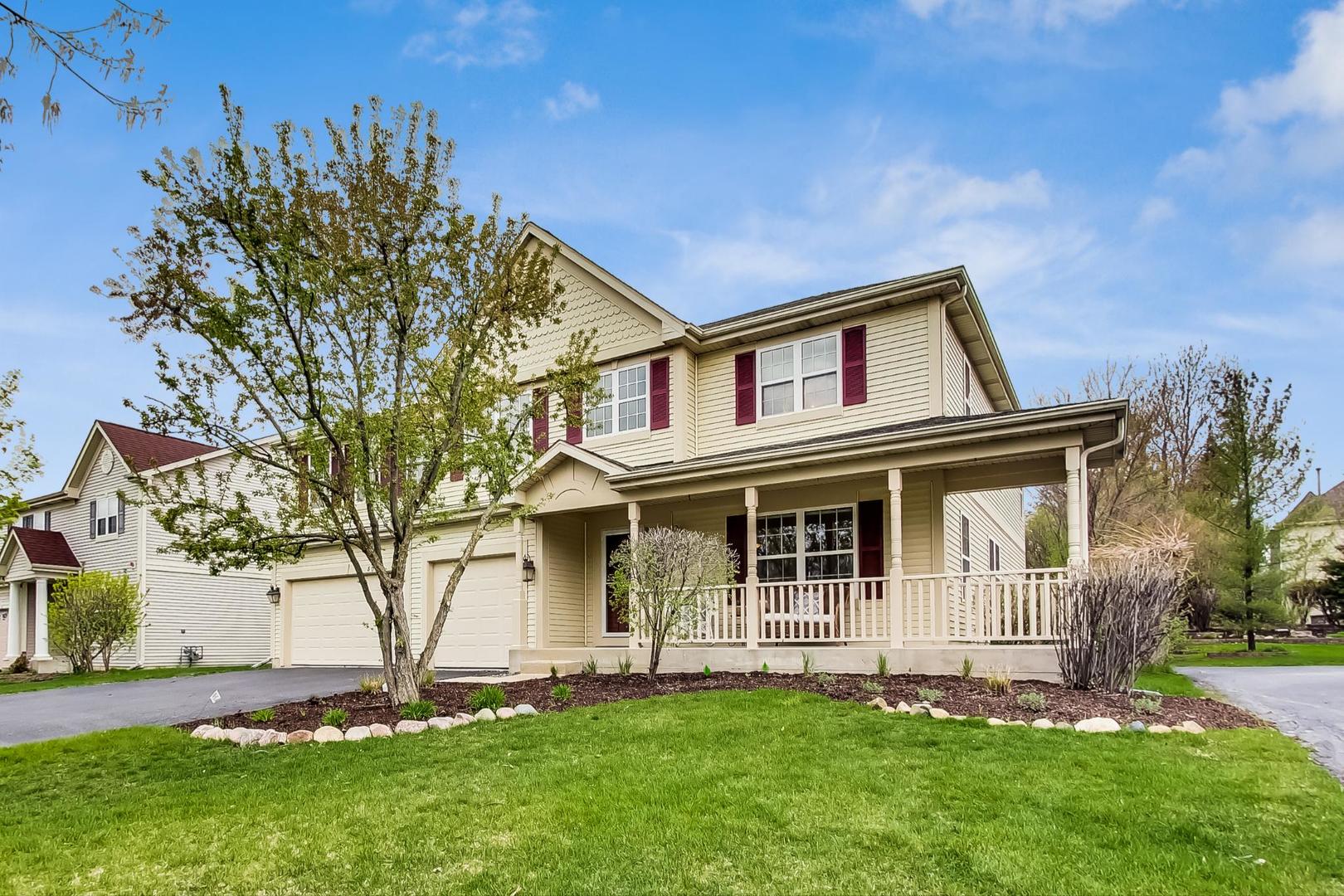 a large tree in front of a house with a yard