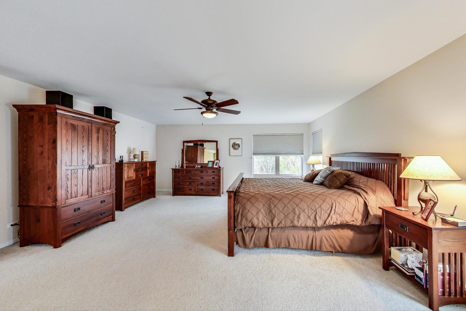 8052 Orchard Commons West Long Grove, IL 60060 - Photo 18 of 32 a spacious bedroom with a bed and a ceiling fan