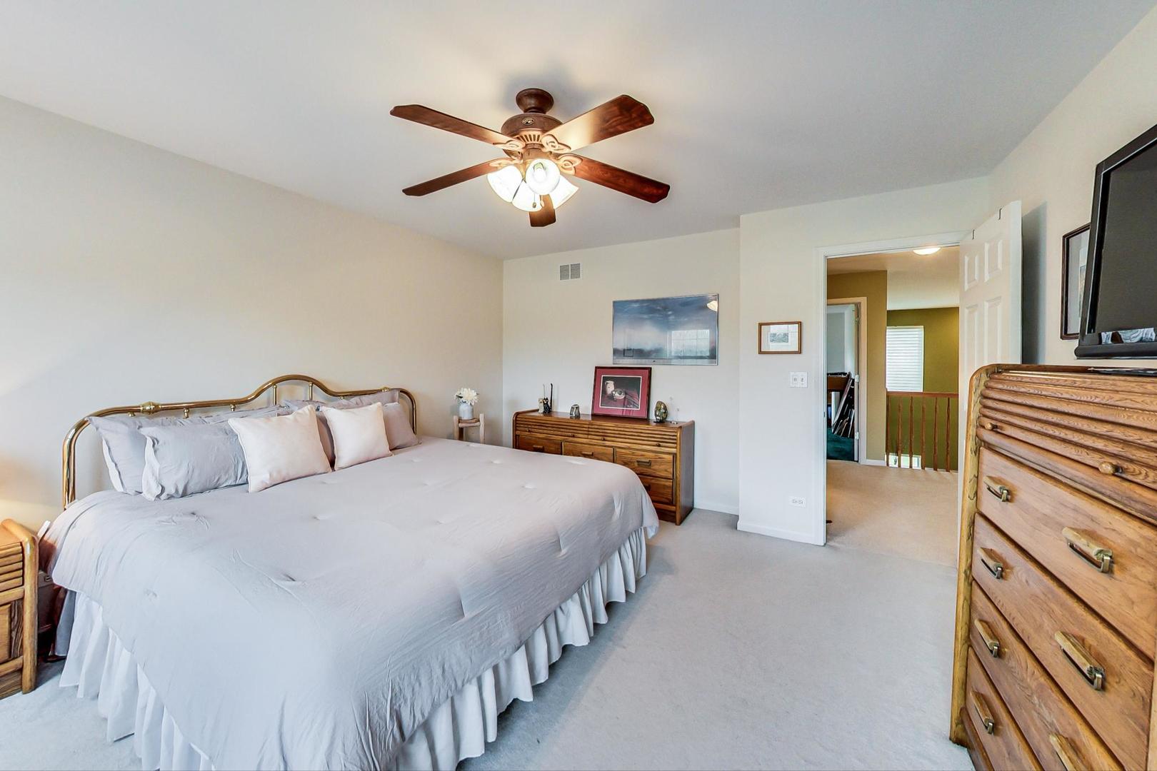 8052 Orchard Commons West Long Grove, IL 60060 - Photo 21 of 32 a spacious bedroom with a bed and a chandelier
