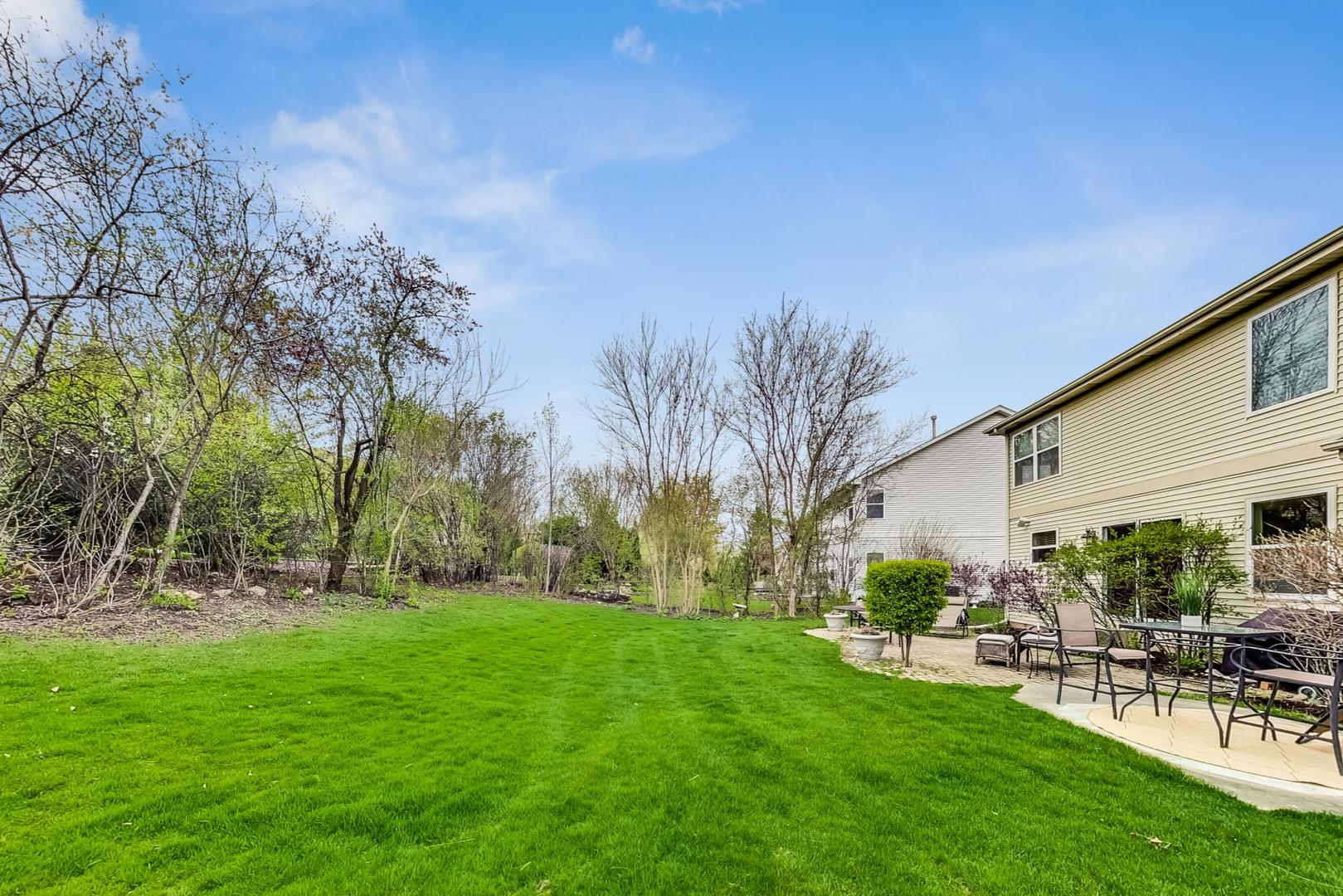 8052 Orchard Commons West Long Grove, IL 60060 - Photo 27 of 32 a view of a patio with table and chairs and potted plants with large tree