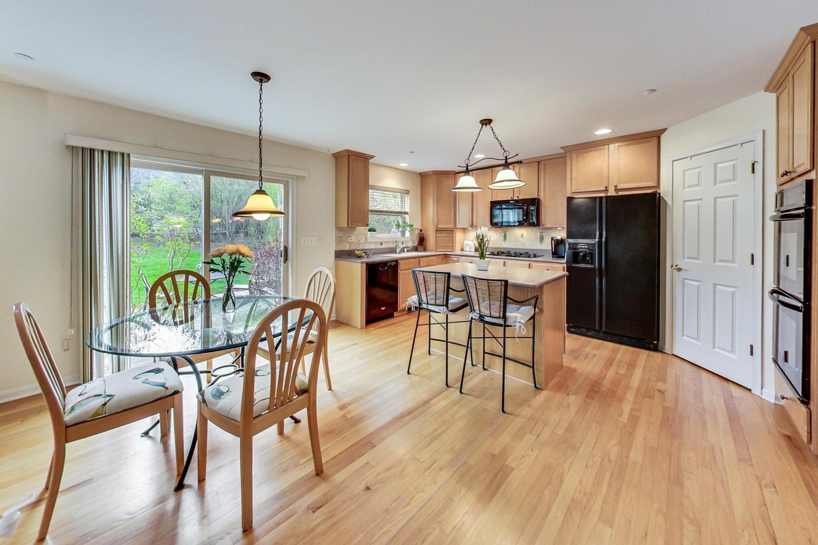 8052 Orchard Commons West Long Grove, IL 60060 - Photo 8 of 32 a view of a dining room and livingroom with furniture wooden floor a chandelier