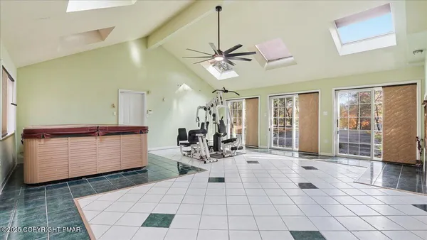 an empty room with windows and chandelier fan