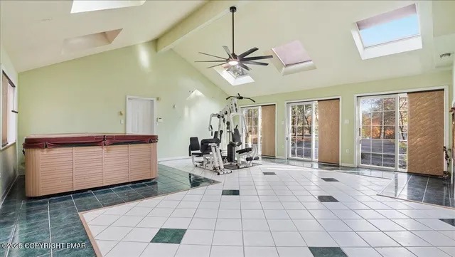 an empty room with windows and chandelier fan