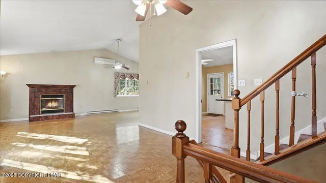 a view of an empty room with window and a kitchen