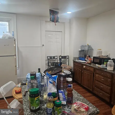 a kitchen with granite countertop lots of clutter and stainless steel appliances