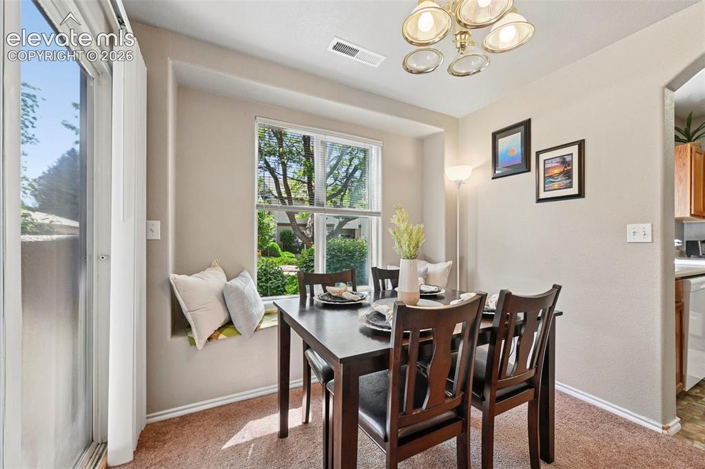 3715 Riviera Grove, Unit 101 Colorado Springs, CO 80922 - Photo 36 of 36 Dining area featuring a built-in window seat, a framed window, and carpet flooring