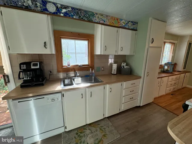 a kitchen with stainless steel appliances granite countertop a sink a stove and a wooden floor