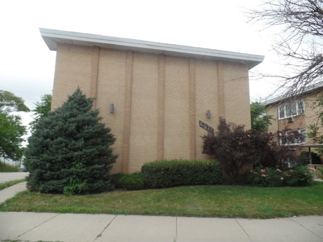 6028 South Archer Road, Unit 2 Summit, IL 60501 - Photo 1 of 6 a brick house with a small yard and plants