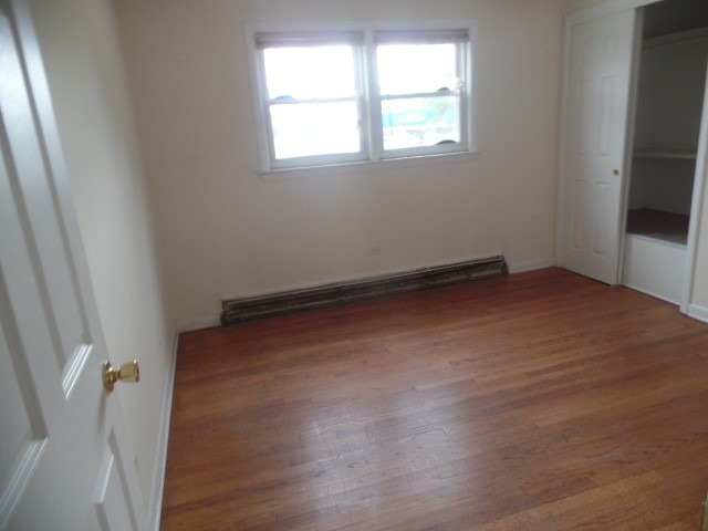 6028 South Archer Road, Unit 2 Summit, IL 60501 - Photo 6 of 6 an empty room with wooden floor and windows