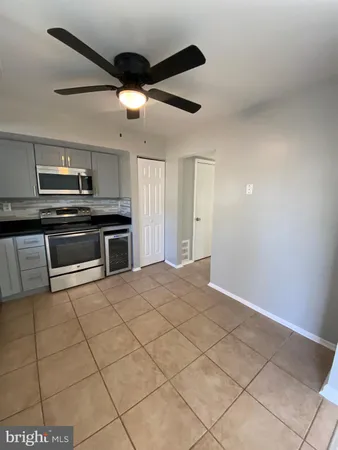 a large kitchen with granite countertop a stove a sink and a refrigerator