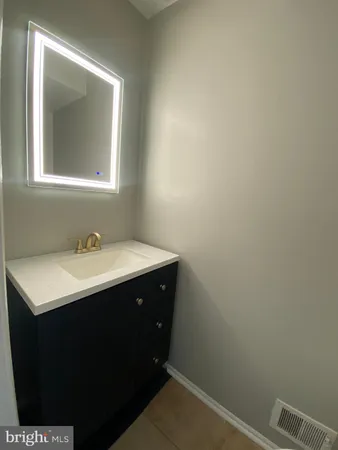 a bathroom with a sink vanity and mirror