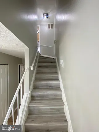 a view of staircase with lots of frames on wall