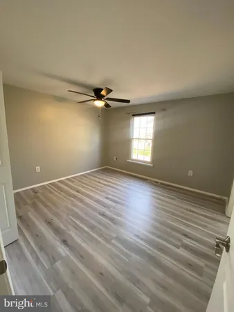 a view of empty room with window and wooden floor
